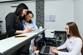 Patient interacting with team members at front desk