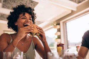 Happy woman preparing to bite into a burger