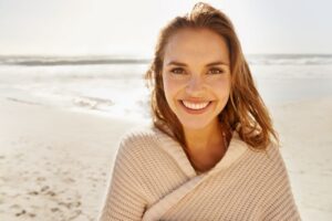 Smiling, happy woman standing on the beach