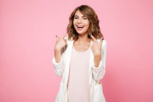 Happy young woman pointing at her beautiful smile